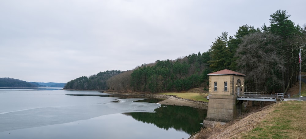 a small tower sitting on top of a hill next to a body of water