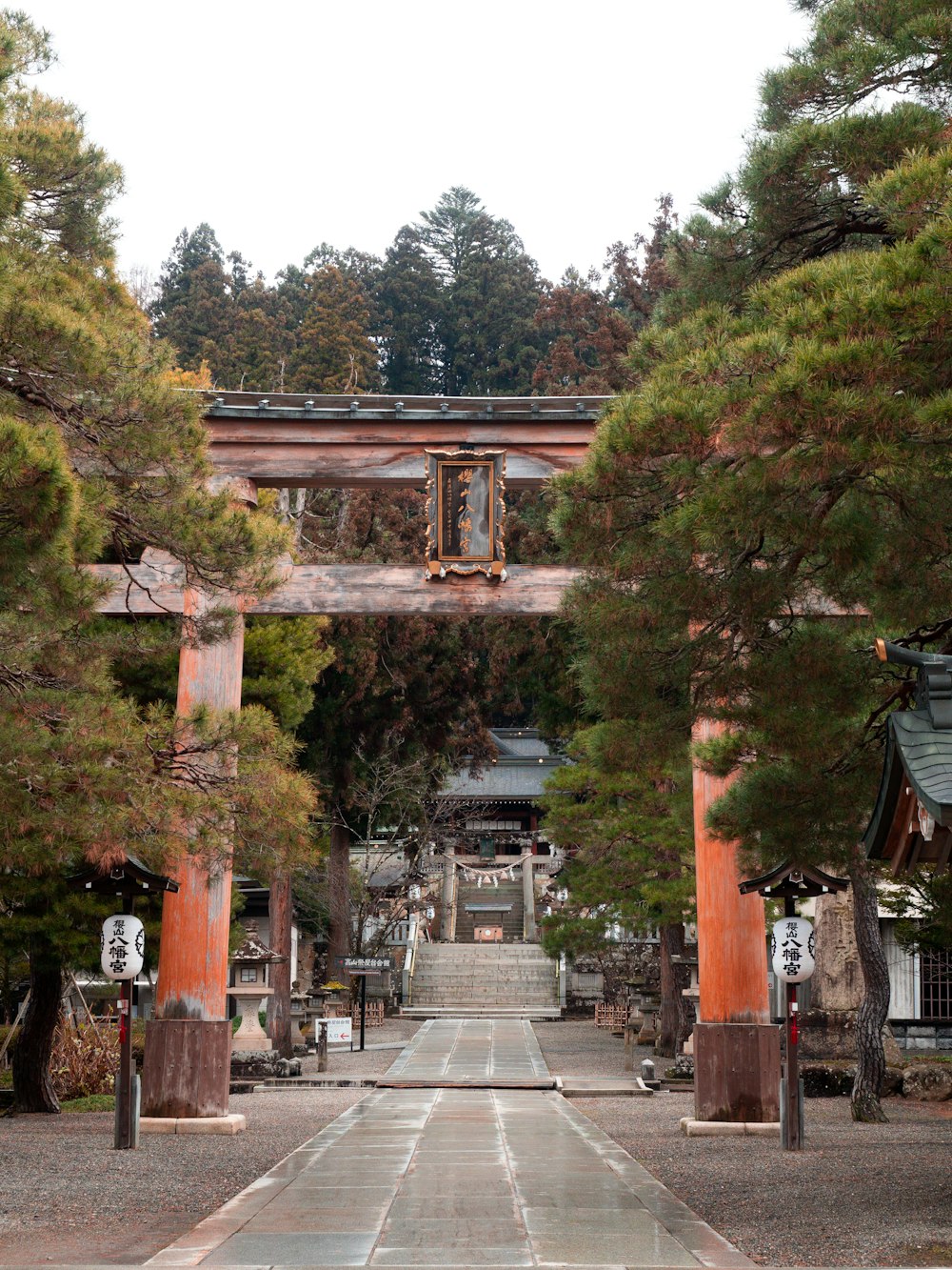 a walkway leading to a building surrounded by trees