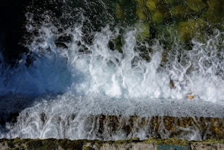 the water is crashing over the edge of a cliff