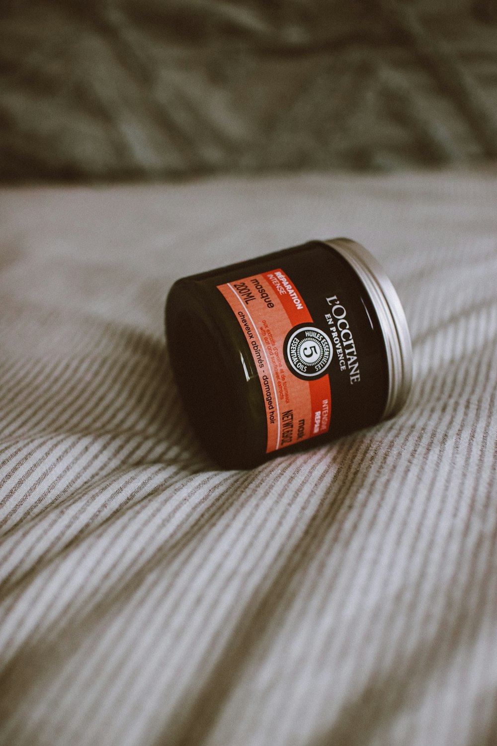 a can of deodorant sitting on a bed