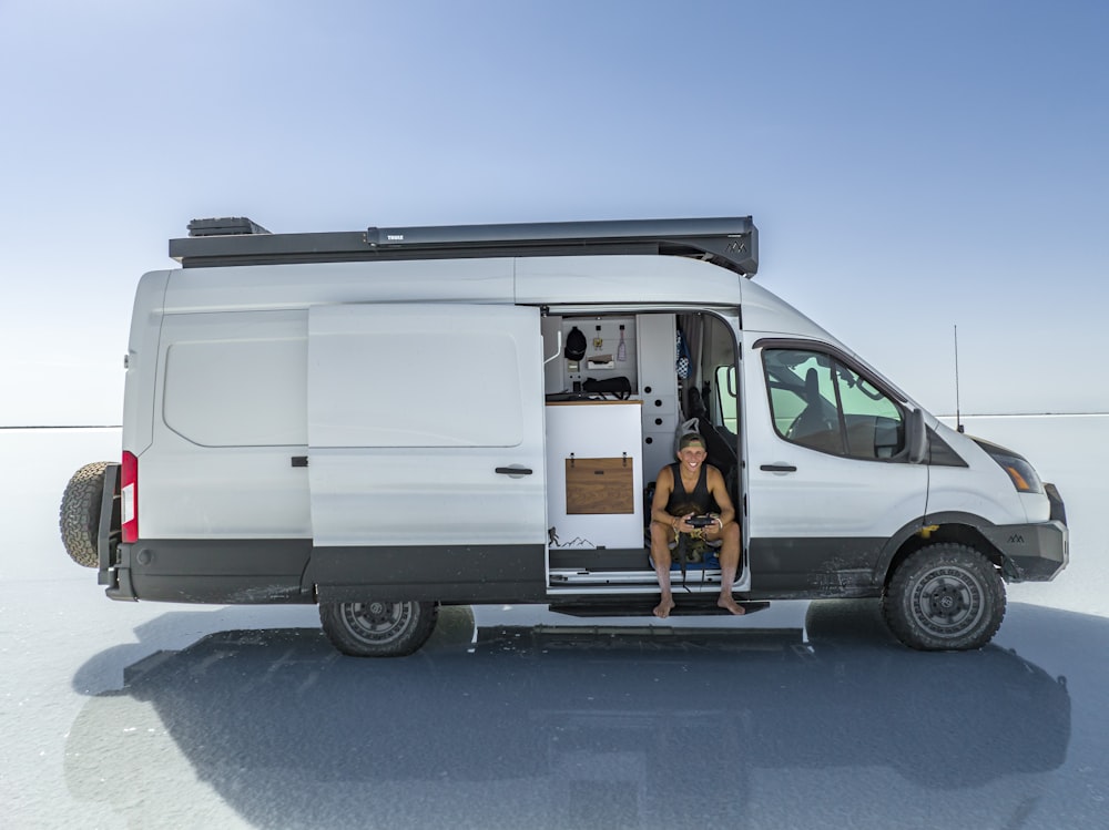 a woman sitting in the back of a white van