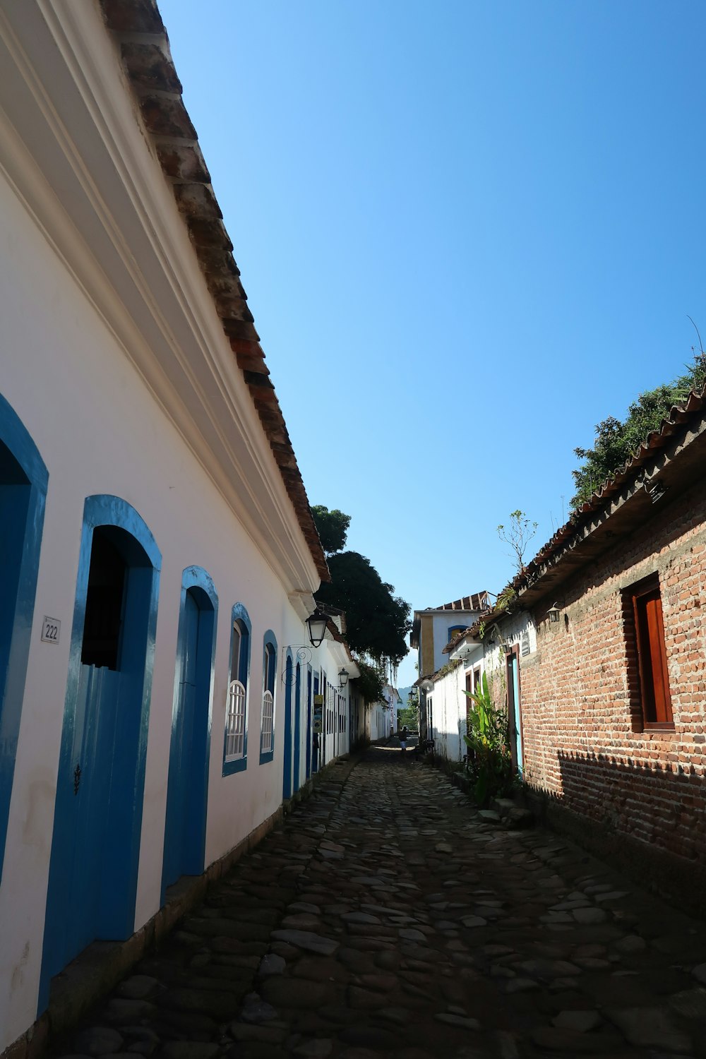a cobblestone street lined with white and blue buildings