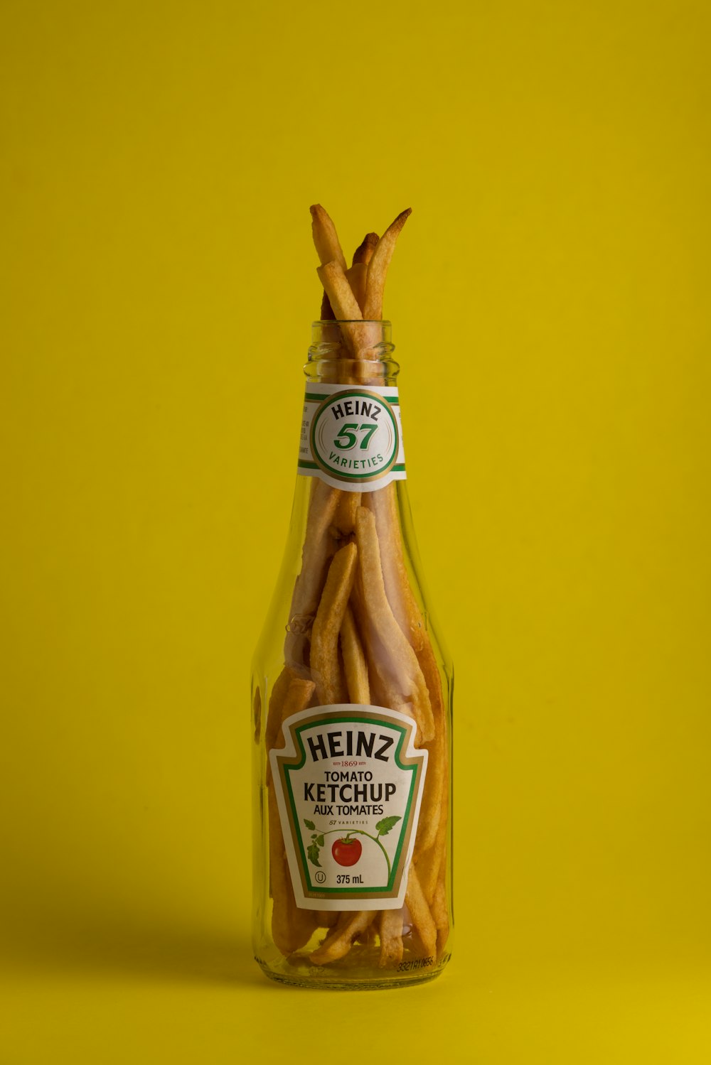 a glass bottle filled with ketchup covered pretzels