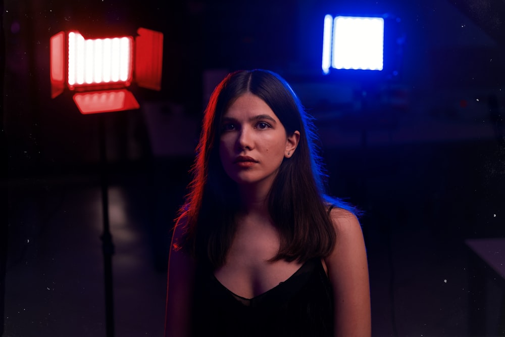 a woman standing in front of a light in a dark room