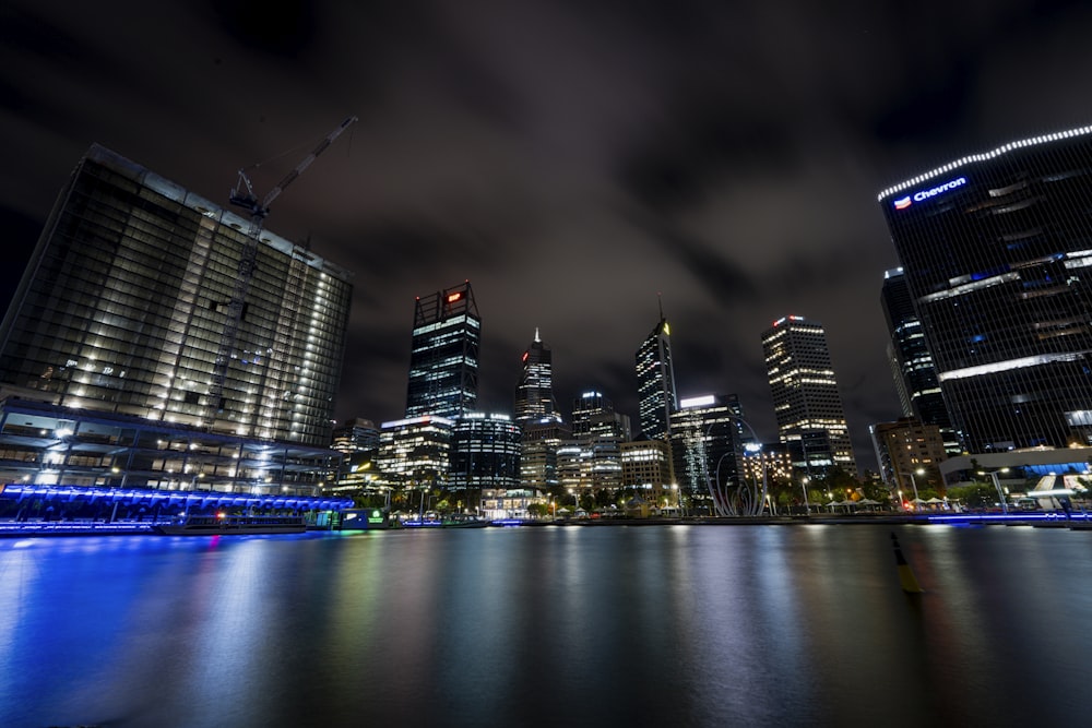 a city at night with lights reflecting in the water