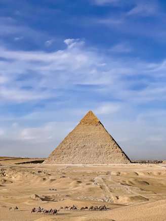 a group of people riding camels in front of a pyramid