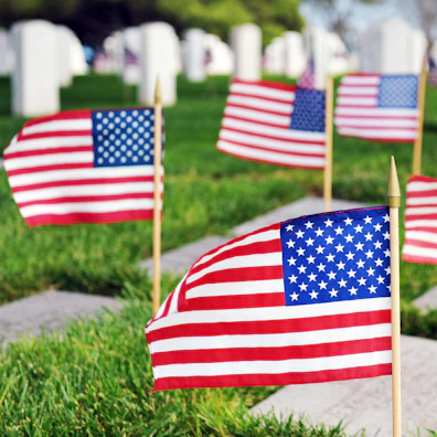 A close-up of a folded American flag resting gently on a soldier’s grave.