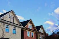 A charming neighborhood street lined with well-kept houses under a clear blue sky.