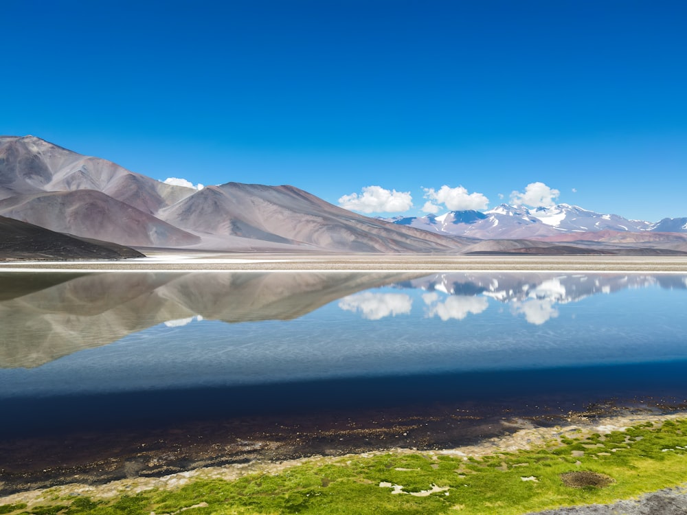 a body of water with mountains in the background