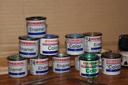 a group of paint cans sitting on top of a wooden table