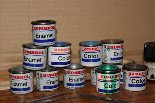a group of paint cans sitting on top of a wooden table