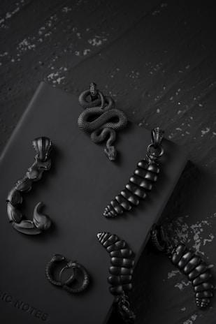 Handcrafted jewelry pieces with Egyptian motifs arranged on black velvet.