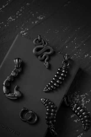 Elegant resin jewelry pieces displayed on a dark charcoal background highlighting their glossy finish.