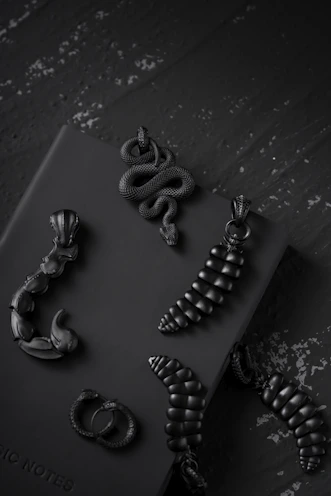 Collection of gothic and metal accessories including rings, chokers, and bracelets on black velvet