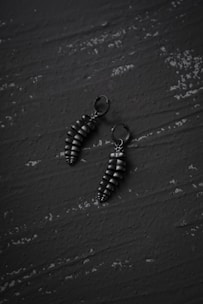 Minimalist black and white image of a pair of stylish earrings
