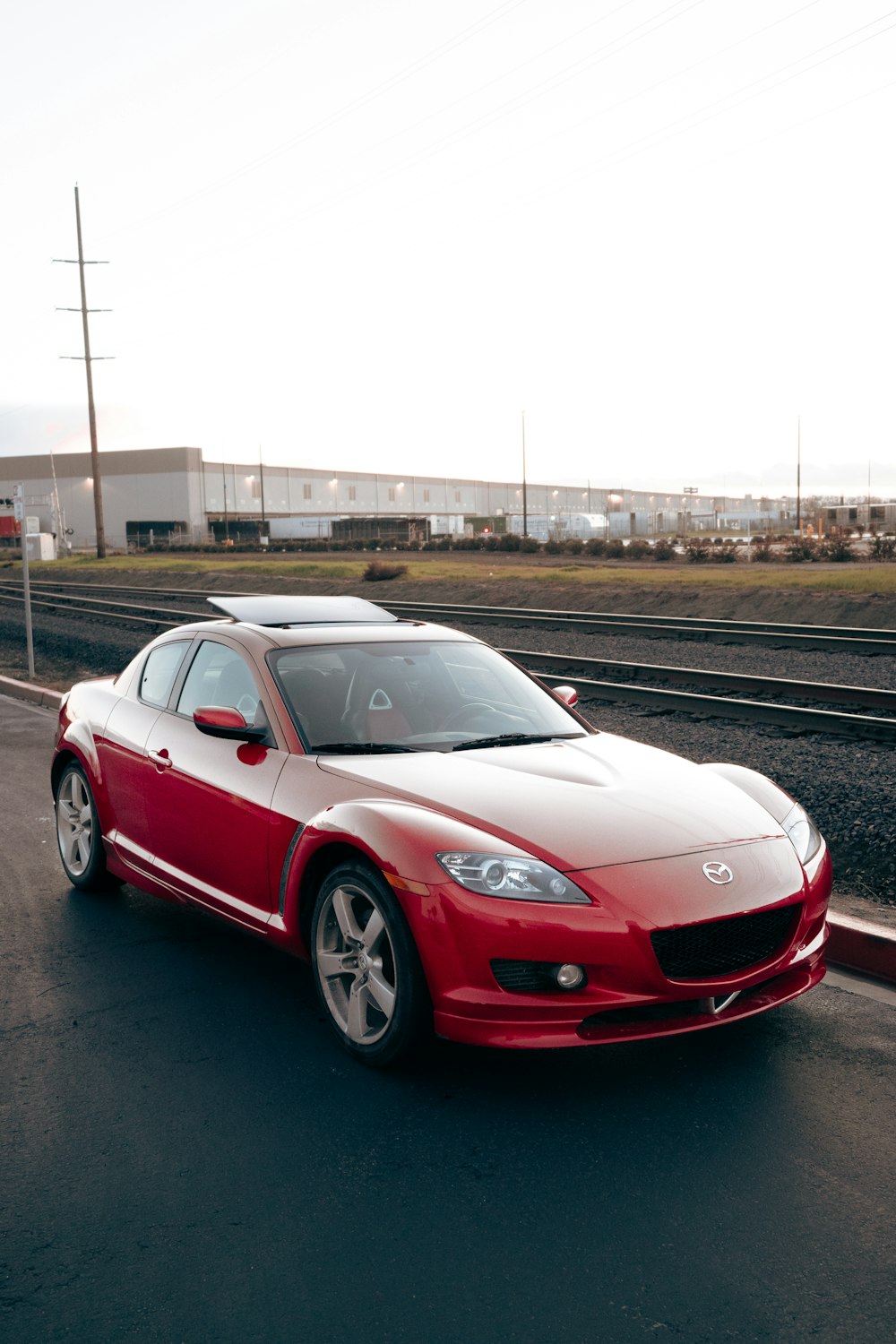 a red sports car driving down the road