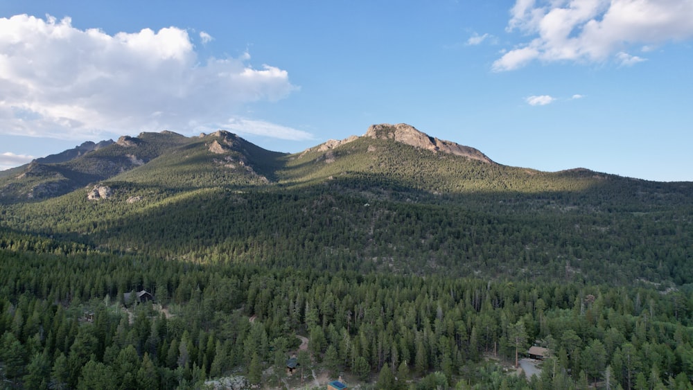 a view of a mountain range with trees and mountains in the background