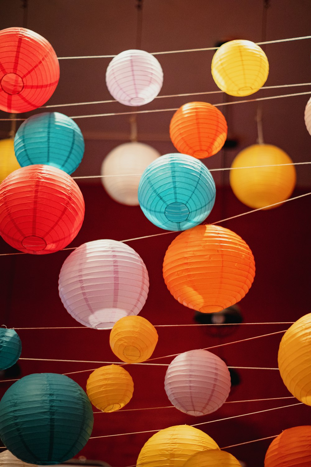 a bunch of colorful paper lanterns hanging from strings