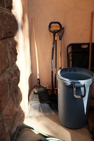 a bucket and shovels sitting next to a brick wall