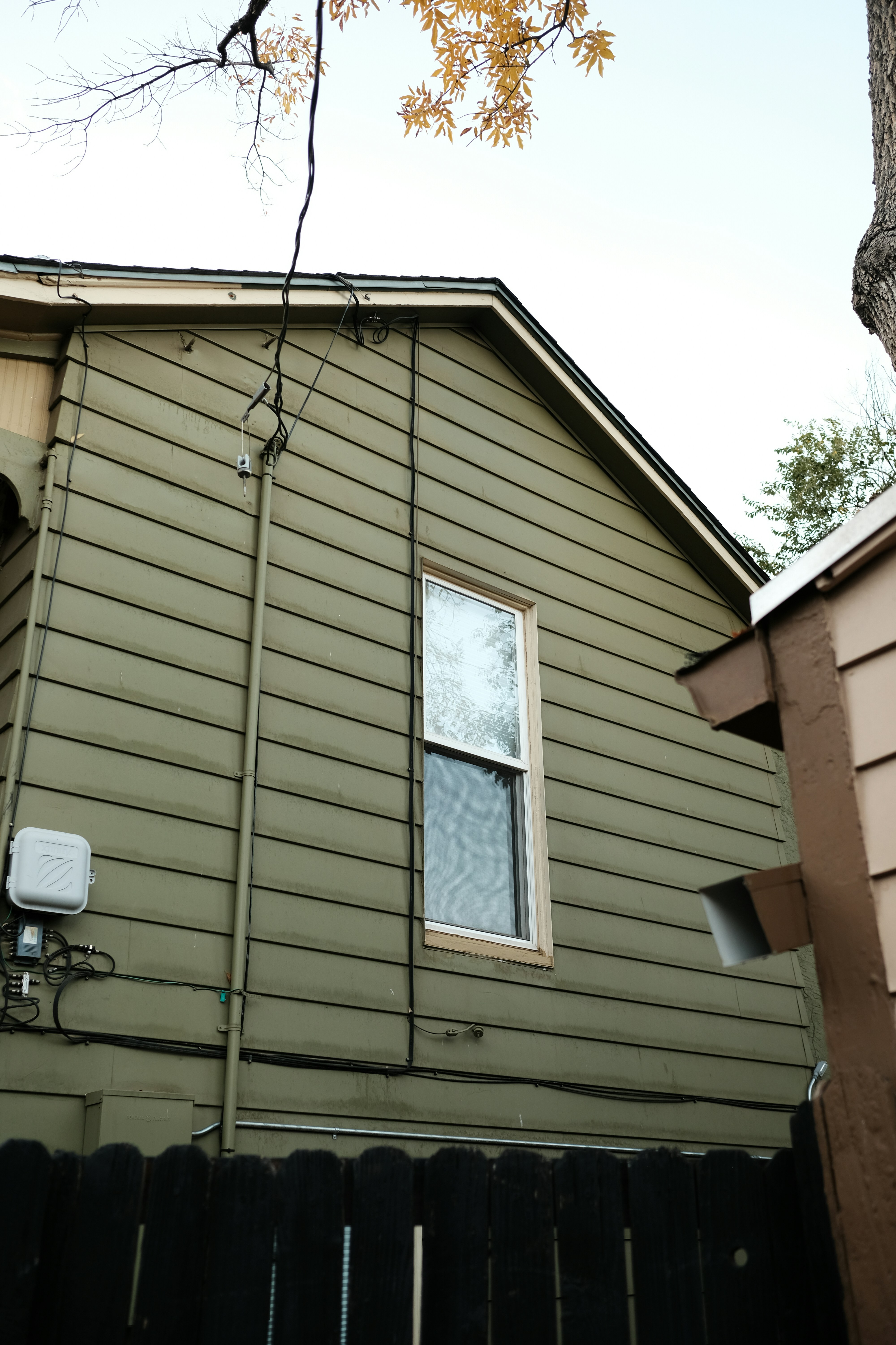 a brown house with a black fence and a window