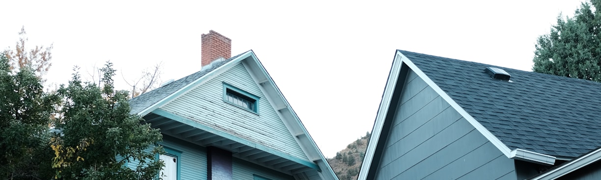 a gray house with a white door and a black fence