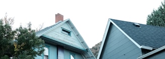 a gray house with a white door and a black fence