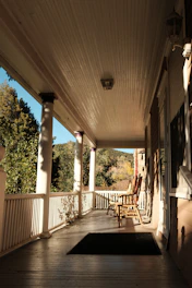 A freshly power-washed porch with gleaming cream railings and a deep navy door, sunlight casting soft shadows.