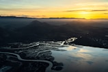 A wide shot of a river delta branching out into multiple streams under a soft sunset.
