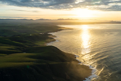 A sweeping aerial shot of the Giant’s Causeway coastline bathed in golden sunset light.