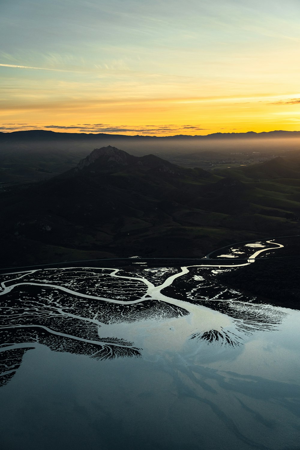 the sun is setting over a mountain range