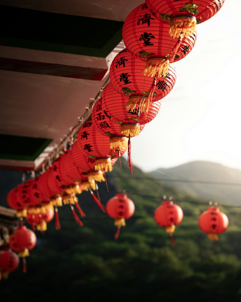 a row of red lanterns hanging from a roof