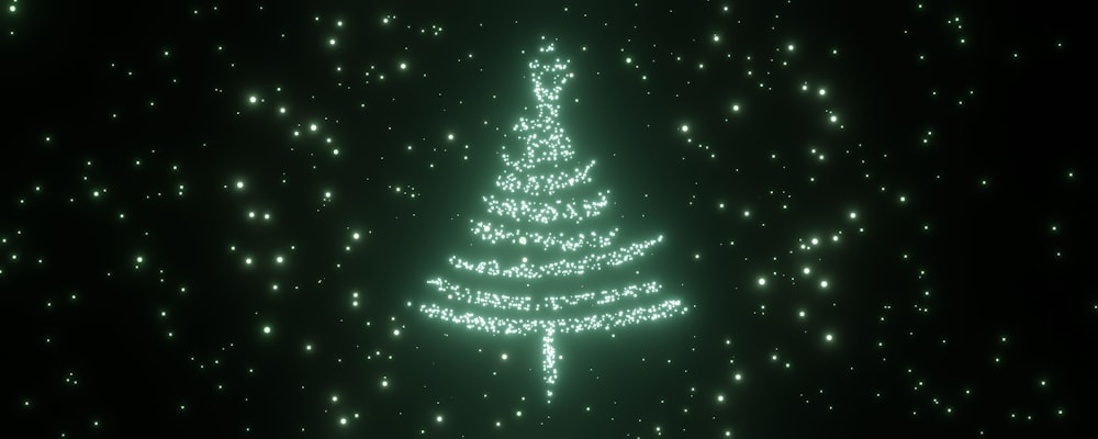 a green christmas tree is lit up in the dark