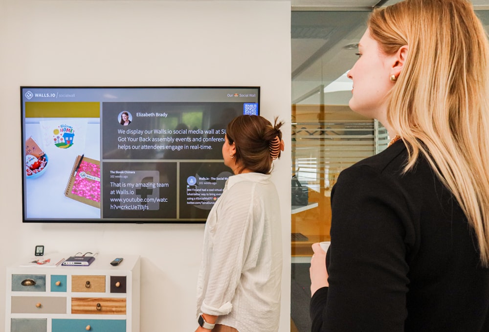 a woman standing in front of a flat screen tv