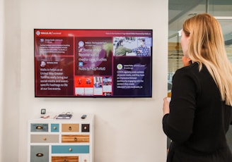 a woman standing in front of a large television