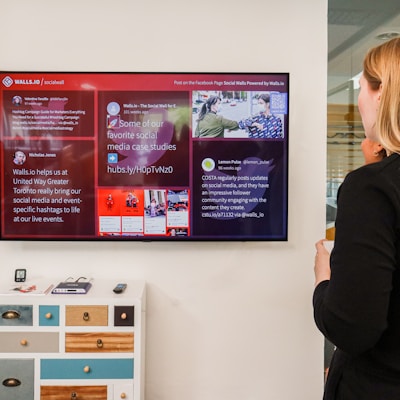 a woman standing in front of a large television