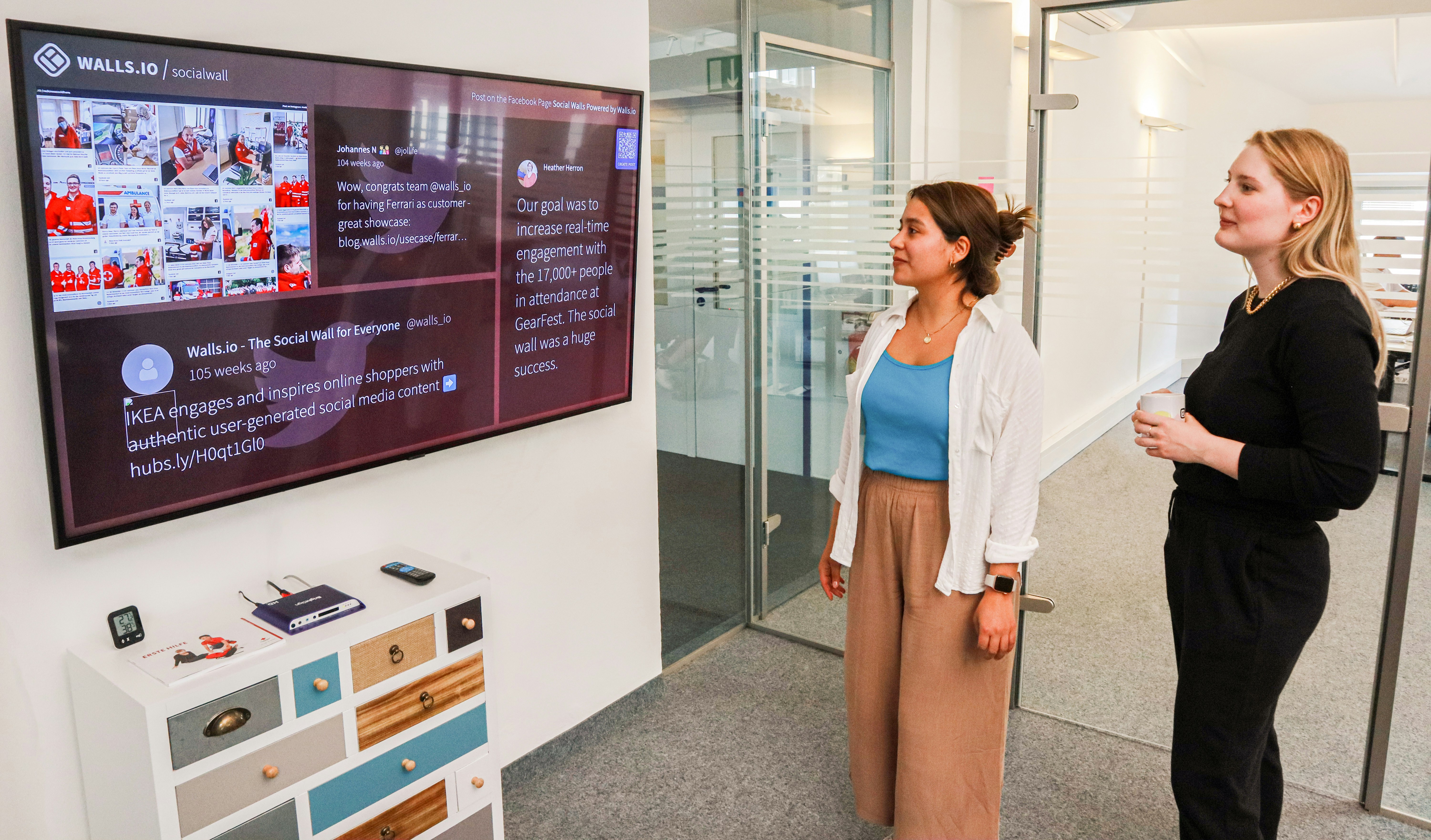 two women standing in front of a flat screen tv