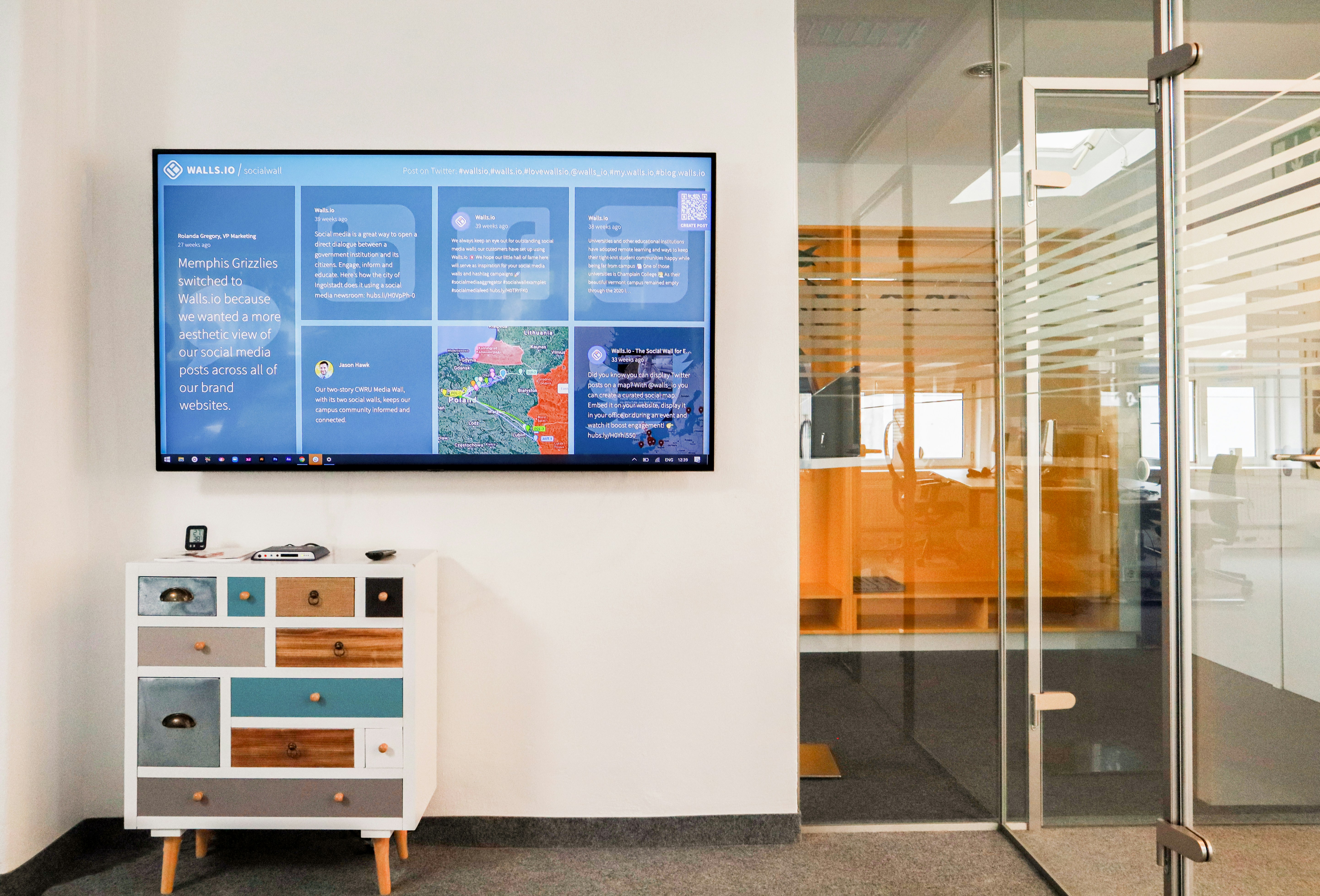 Open office space with a screen showing company news