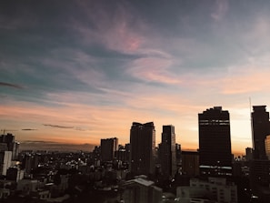 A city skyline at dusk with blue hues mirroring drb's brand colors.