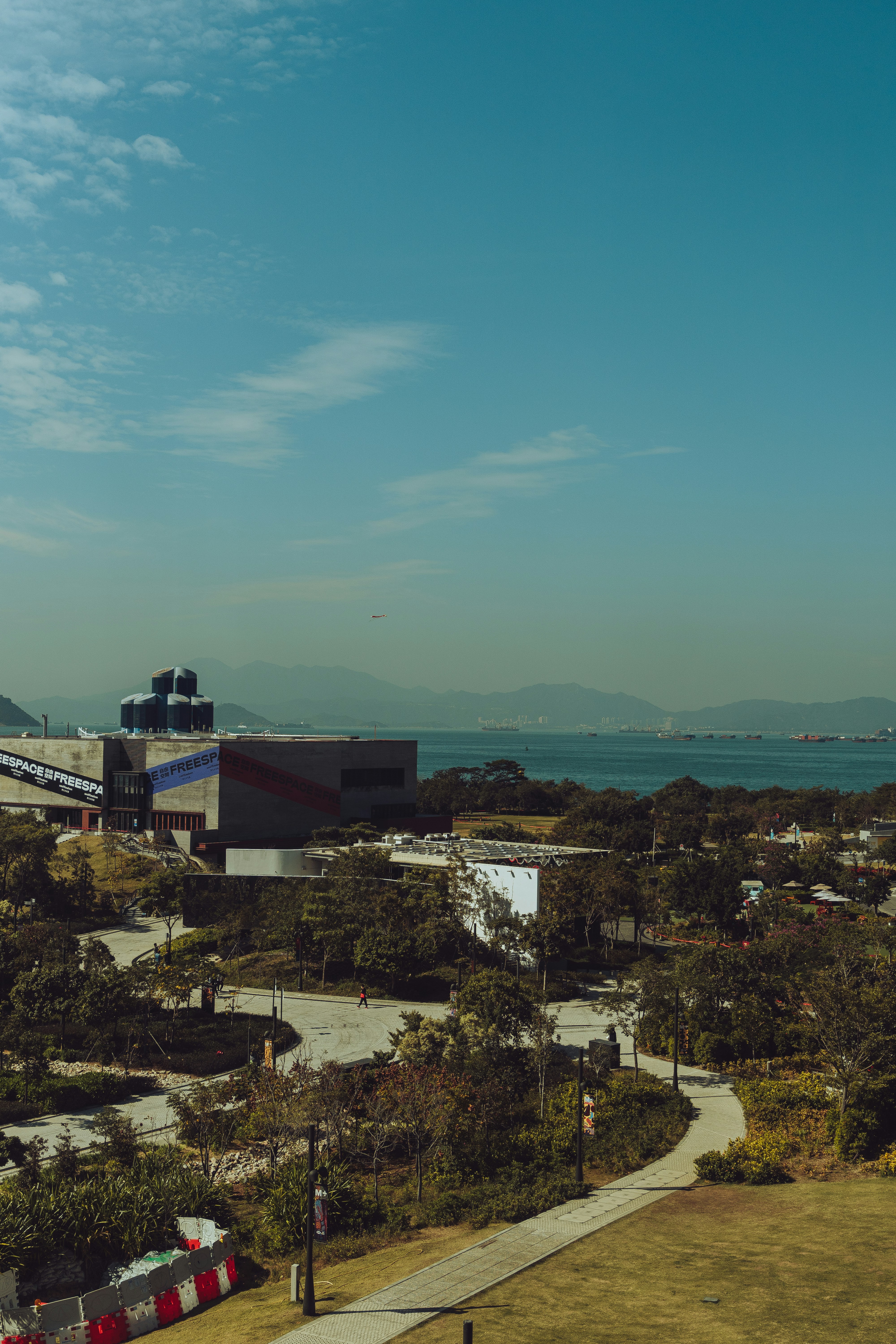 a plane is flying over a city by the water