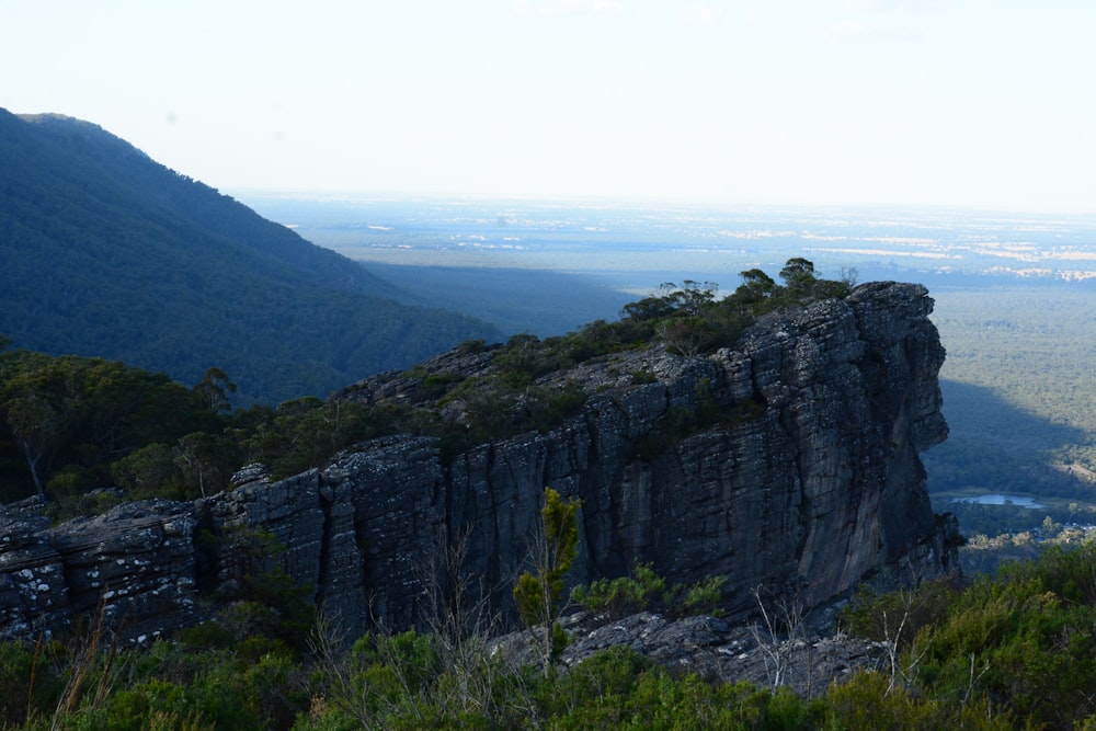 a view of a valley and mountains from the top of a hill