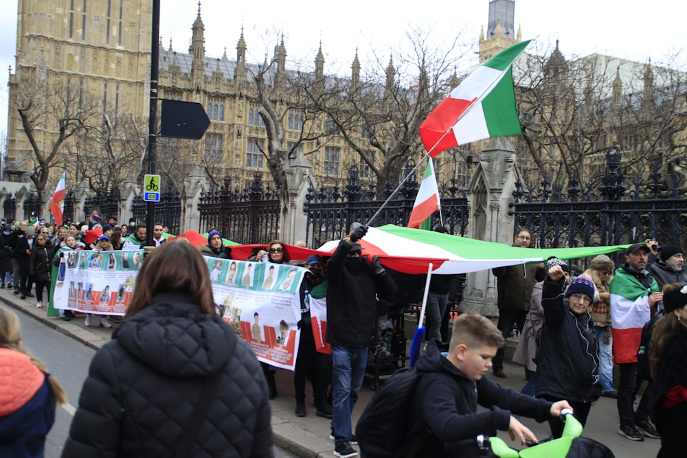 a group of people on a street with flags and banners