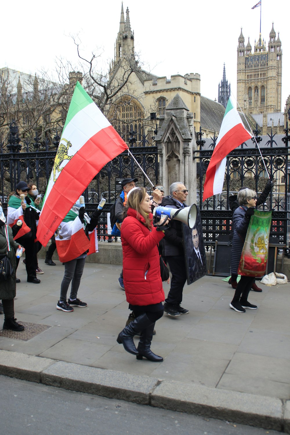 a group of people walking down a street holding flags