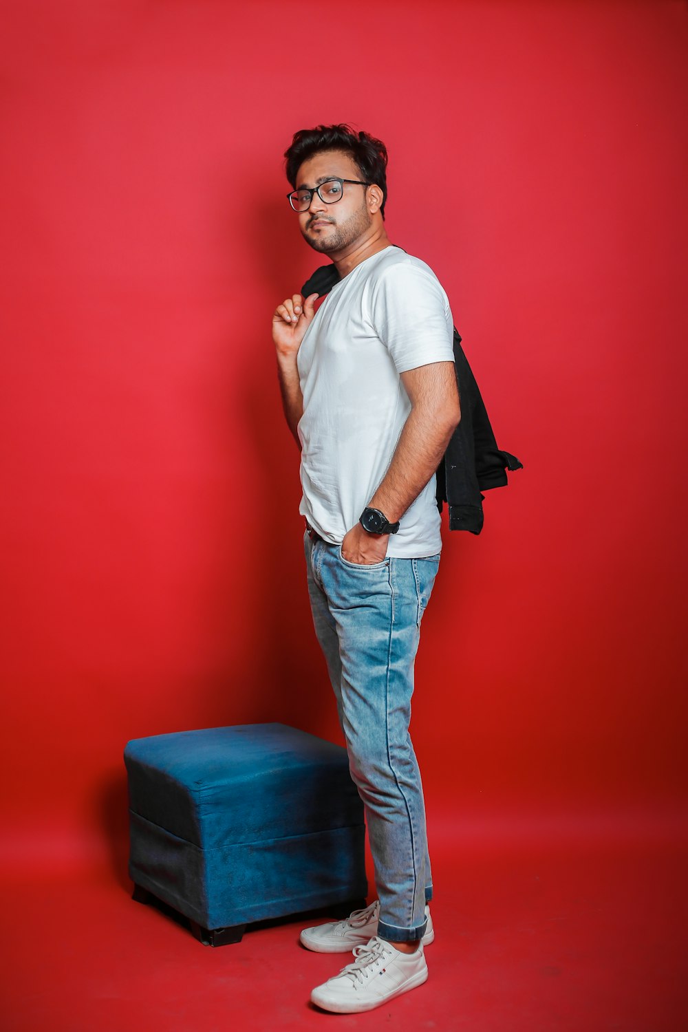 a man standing in front of a red wall