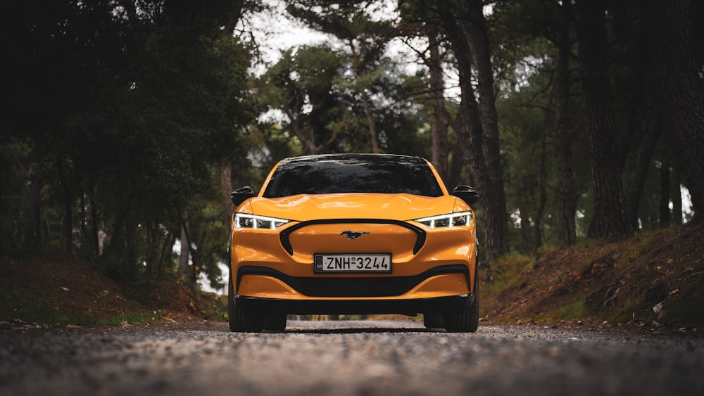 a yellow car is driving down the road