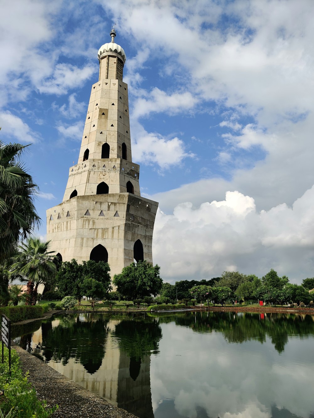a tall tower with a clock on top next to a body of water