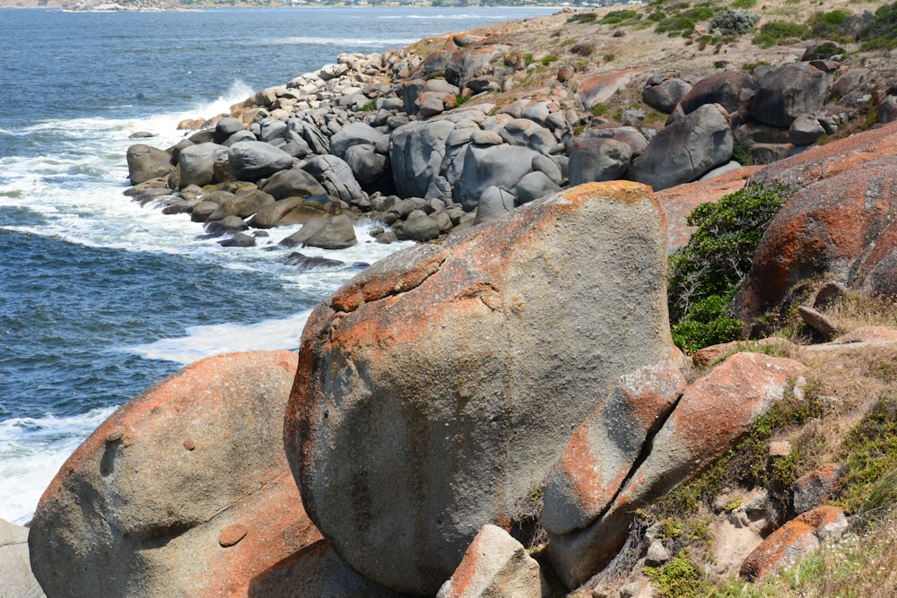 a rocky shore line with a body of water in the distance