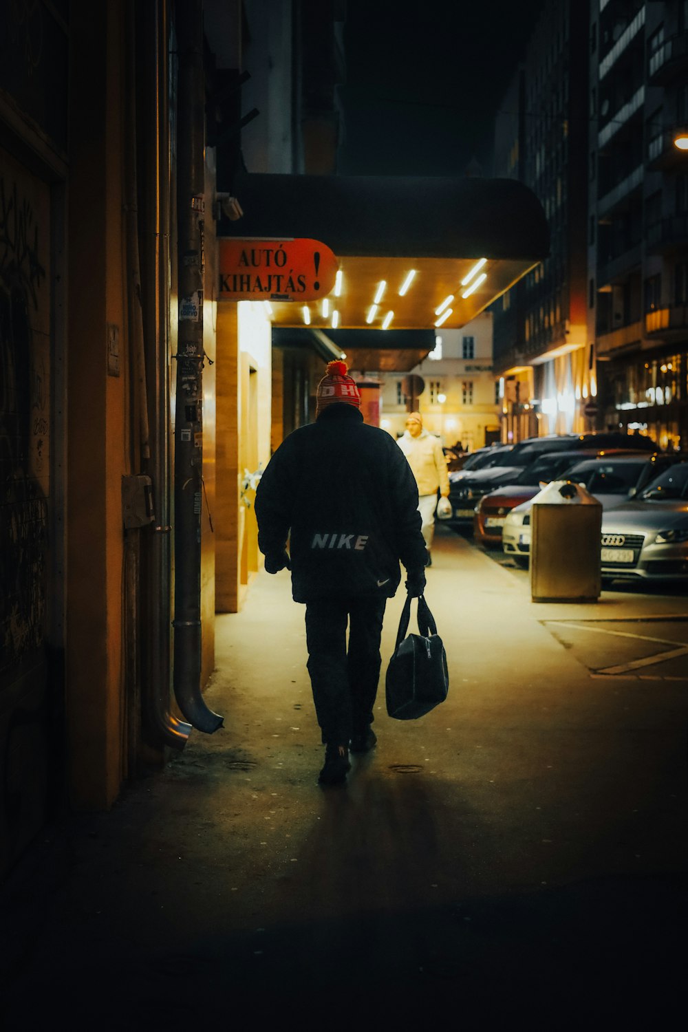 a person walking down a street at night