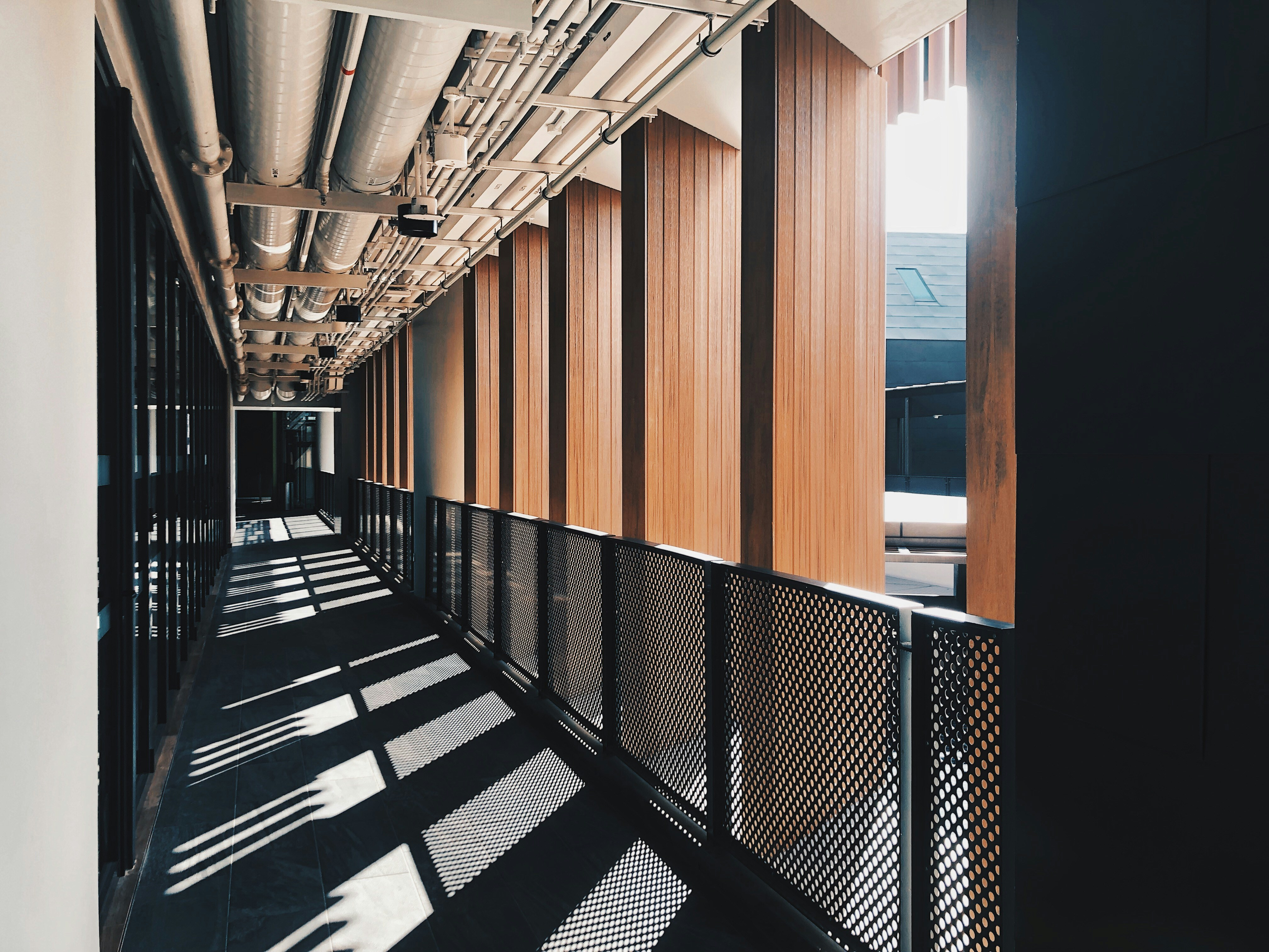 a long hallway with wooden walls and metal railings