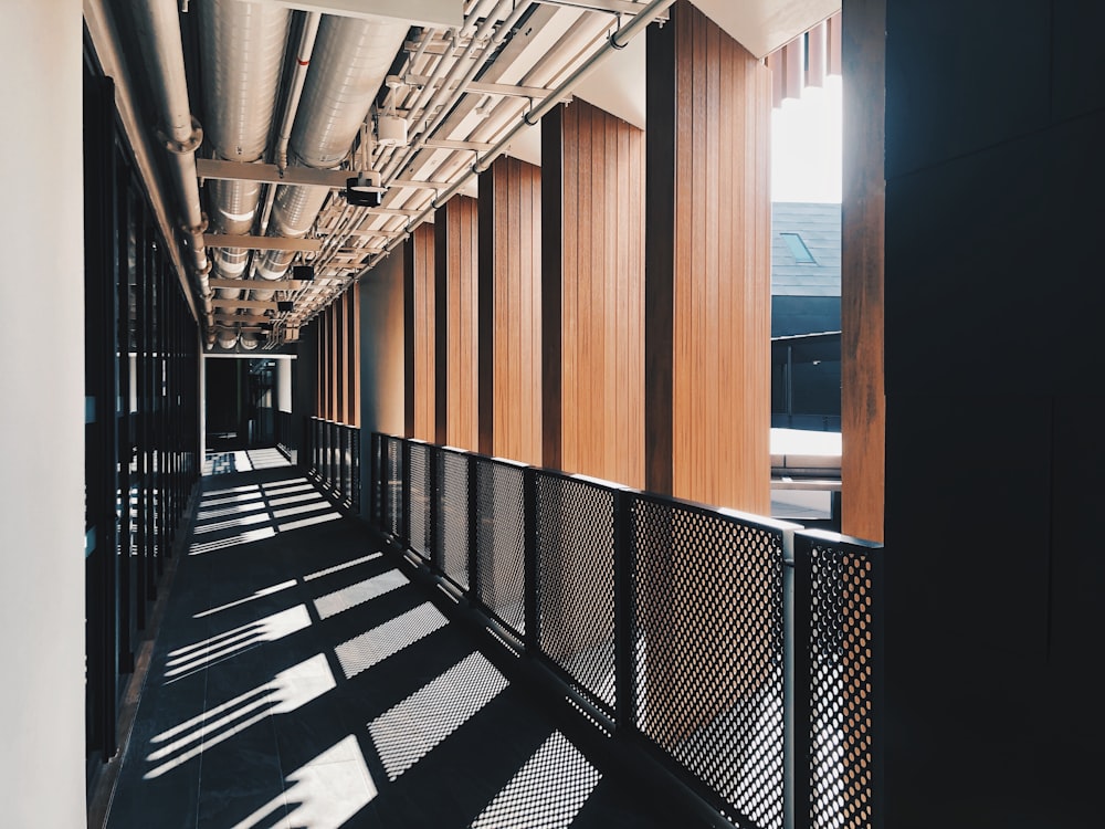 a long hallway with wooden walls and metal railings