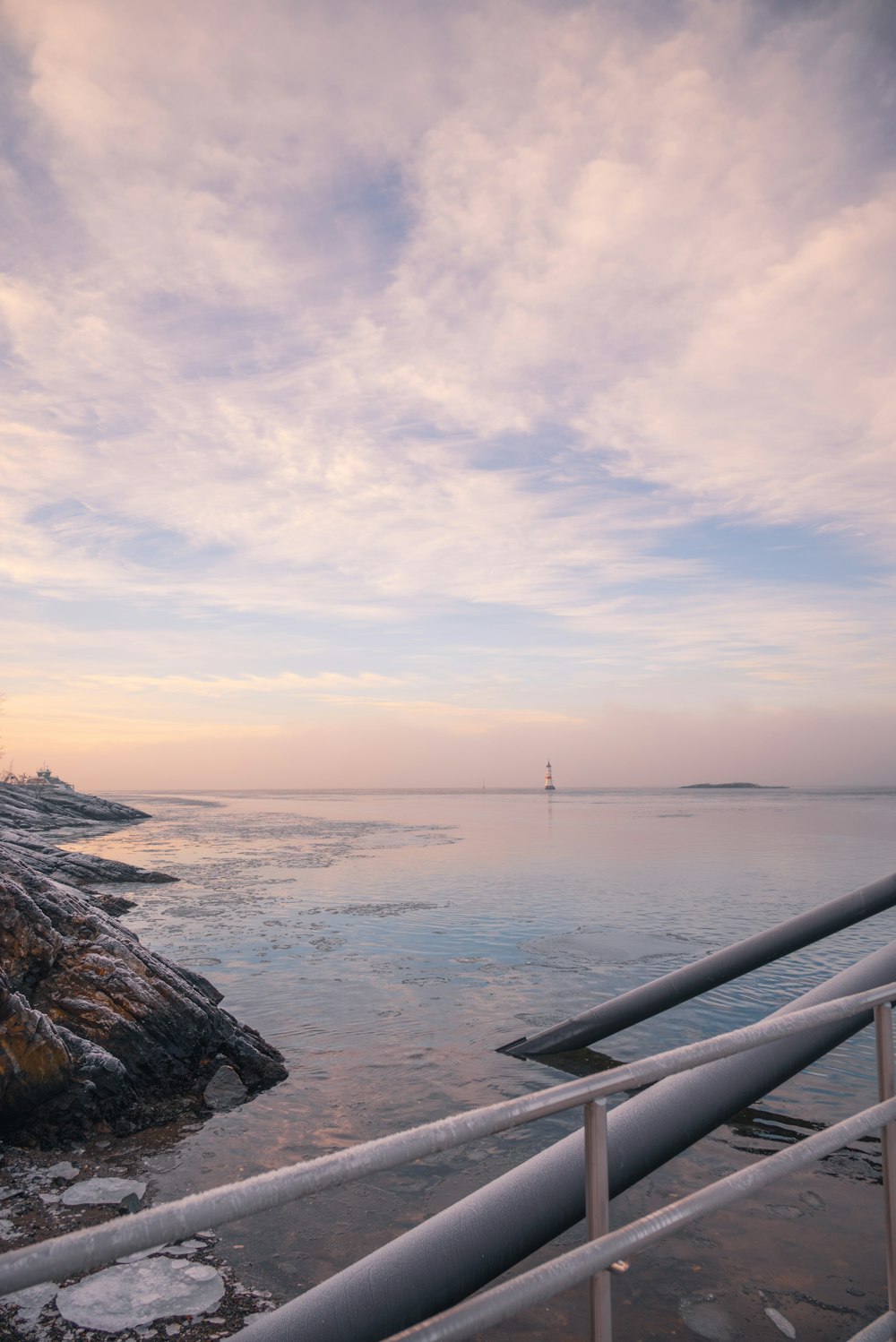 une vue d’un plan d’eau avec un phare au loin